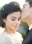 Groom gently kissing bride — Stock Photo