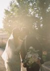 Bräutigam küsst Braut während draußen — Stockfoto