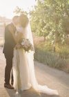 Bräutigam hält und küsst Braut — Stockfoto