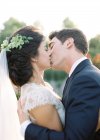 Bräutigam umarmt und küsst Braut — Stockfoto
