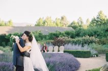 Жених обнимает невесту в саду — стоковое фото