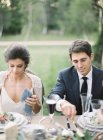 Groom and bride sitting at wedding table — Stock Photo