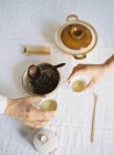 Hände halten Tassen mit grünem Tee — Stockfoto