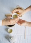 Руки держа чашку чая во время чайной церемонии — стоковое фото