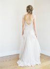 Mulher em vestido de noiva de pé no quarto — Fotografia de Stock