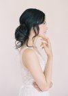 Frau im Hochzeitskleid mit Hand bis Kinn — Stockfoto