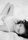 Mulher em lingerie requintada deitada na cama — Fotografia de Stock