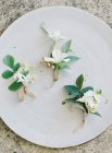 Свадебные бутоньерки на белой тарелке — стоковое фото