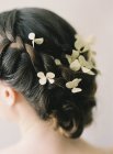Плетене волосся з квітковим прикрасою — стокове фото