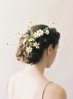 Camomile flowers in braided updo — Stock Photo