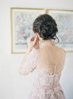 Braut befestigt Ohrringe — Stockfoto