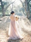 Sposa con mazzo di fiori nella foresta — Foto stock