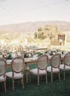 Hochzeitstische mit Blumen und Stuhlreihen — Stockfoto
