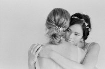 Mujeres en vestidos abrazándose unas a otras - foto de stock