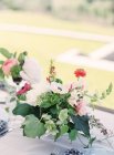 Disposizione floreale sulla tavola apparecchiata — Foto stock