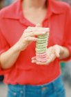 Woman holding stack of macaroons — Stock Photo