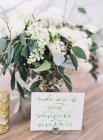 Wedding floral arrangement with note — Stock Photo