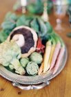 Verduras ecológicas en el plato y en la mesa - foto de stock