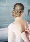 Female hands buttoning wedding dress — Stock Photo