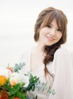 Beautiful young woman with flowers — Stock Photo