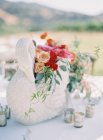 Arranjo floral com estatueta cisne — Fotografia de Stock