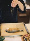Donna cucina pesce — Foto stock