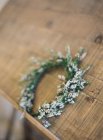 Elegante corona floreale su superficie in legno — Foto stock