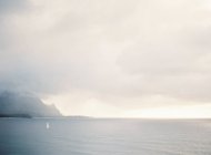 Isla distante y nubes-cabo - foto de stock