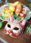 Maschera di carnevale e piatto di frutta fresca — Foto stock