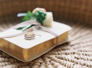 Anéis de casamento no caderno com boutonniere — Fotografia de Stock