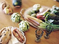 Alcachofras e legumes na mesa — Fotografia de Stock