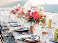 Floral arrangement on setting table — Stock Photo