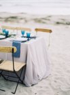 Table set for dinner at beach — Stock Photo