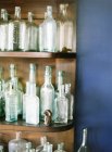 Glasflaschen auf Holzregalen — Stockfoto