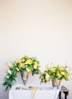 Bouquets of flowers in antique vases — Stock Photo