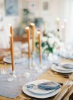 Wooden setting table decorated with candles — Stock Photo