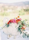 Floral arrangement with swan statuette — Stock Photo