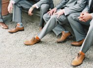 Мужчины в костюмах сидят на улице — стоковое фото