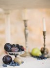 Prunes et baies fraîches en stand antique — Photo de stock