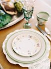 Dinner table with porcelain plates — Stock Photo