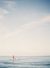 Seascape with person skulling on surfboard on sunny day — Stock Photo