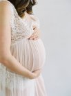 Беременная женщина с руками на животе — стоковое фото