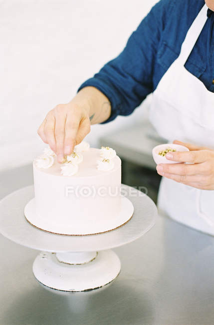 Woman decorating one tier cake — Stock Photo