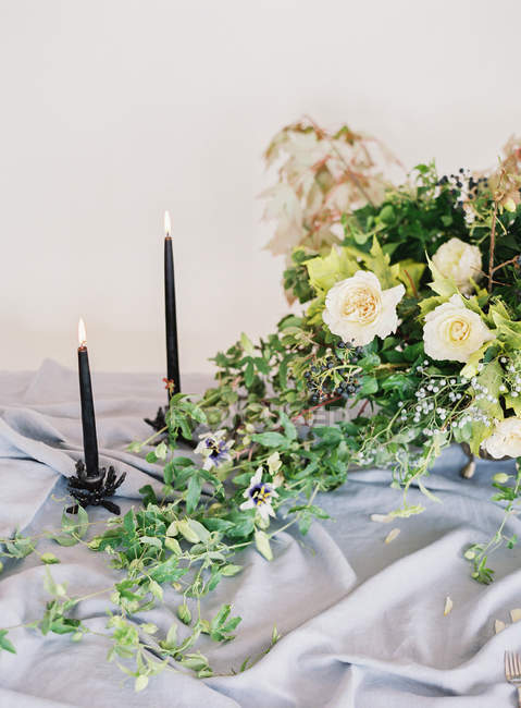 Candles lighting and floral arrangement — Stock Photo