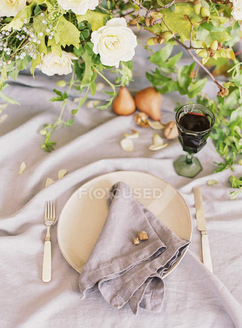 Fresh pears and flowers on setting table — Stock Photo