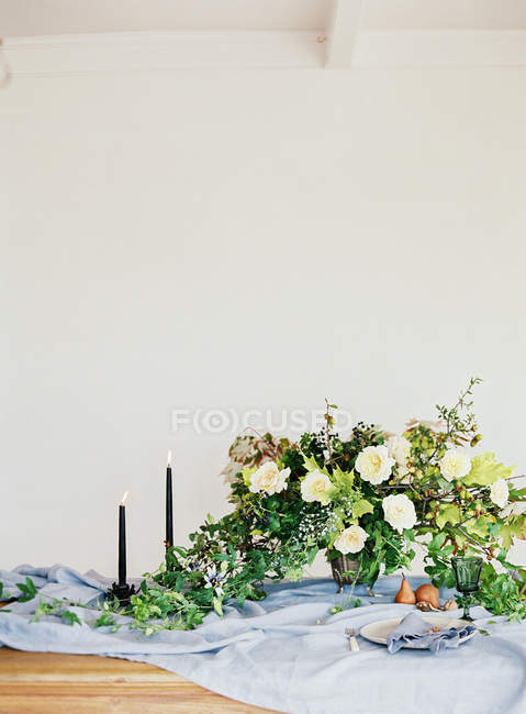 Pears with bouquet of flowers and candles — Stock Photo