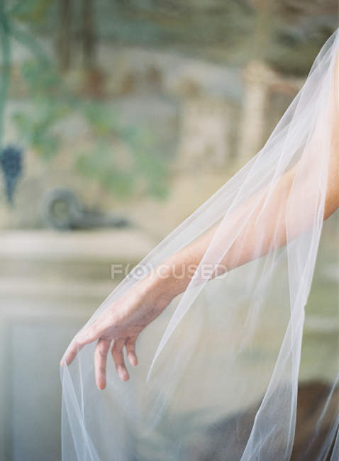 Female hand in bridal veil — Stock Photo