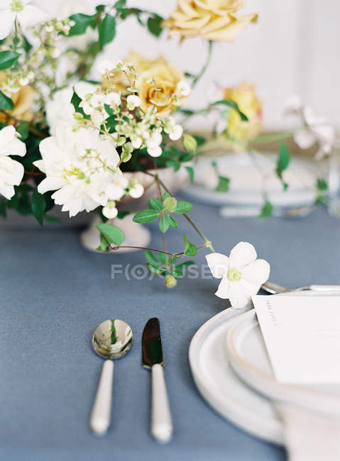 Bouquet de fleurs sur table dressée — Photo de stock