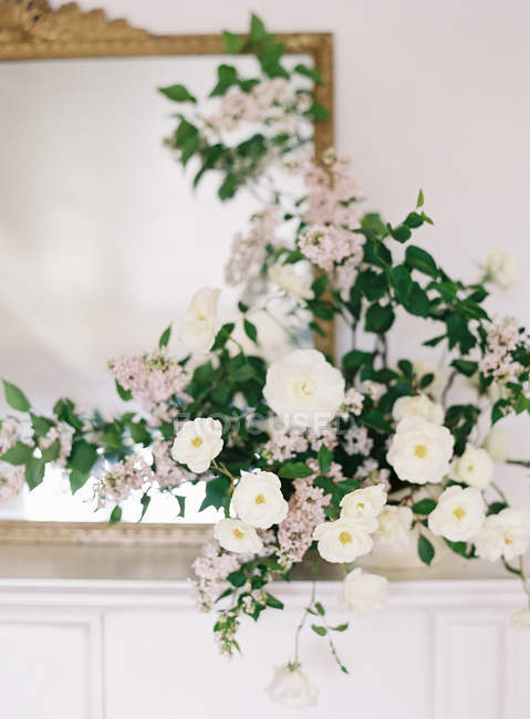 Rosas de setos y flores lila en jarrón - foto de stock