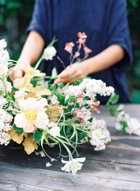 Floristas mãos arranjando flores em buquê — Fotografia de Stock